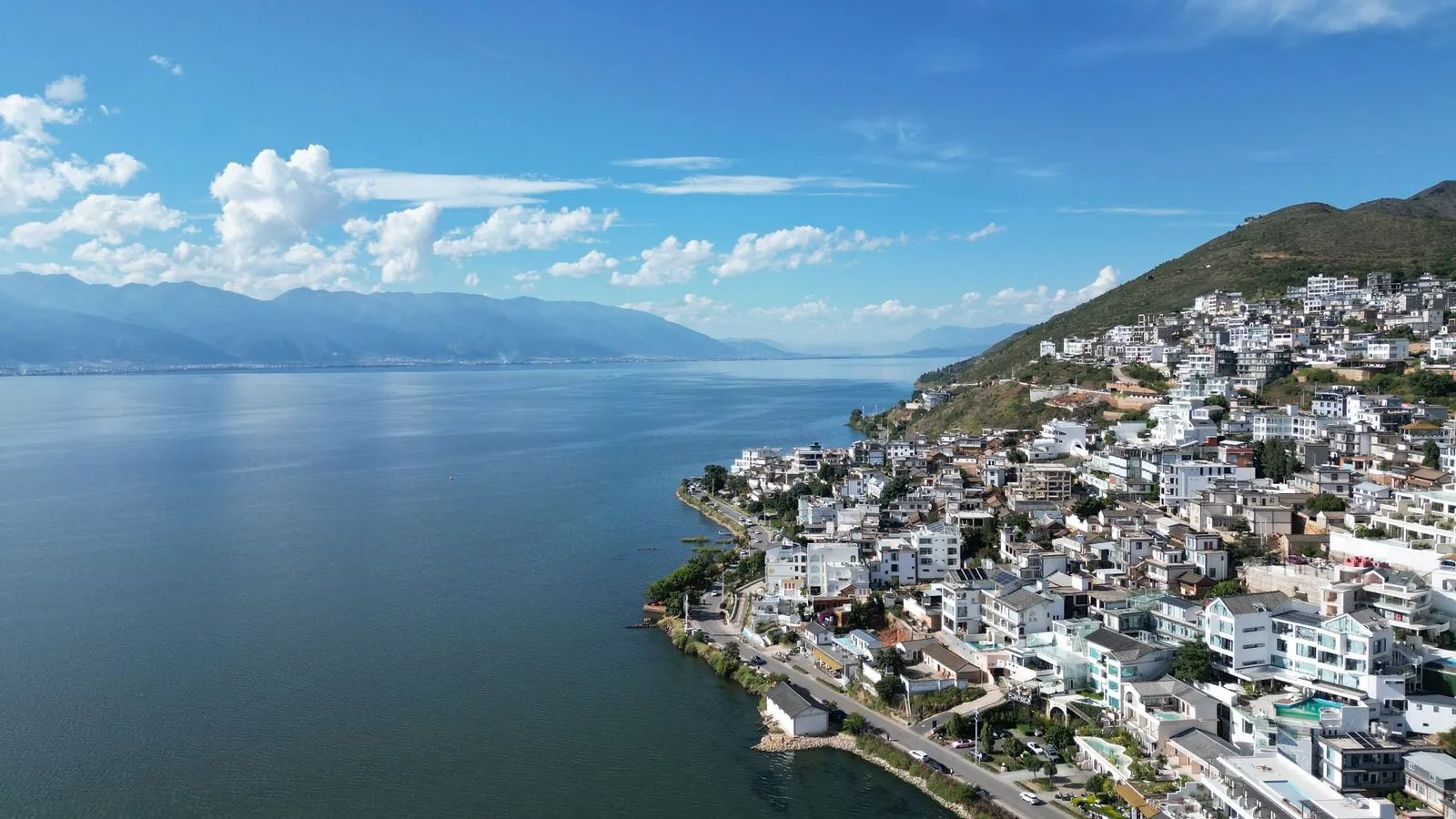 Cycling the Erhai Lake shore near Dali with Cangshan mountains in the background
